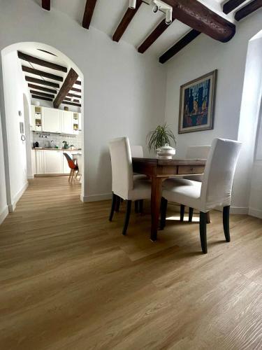 a dining room with a wooden table and white chairs at Casa Pierina in Vicchio