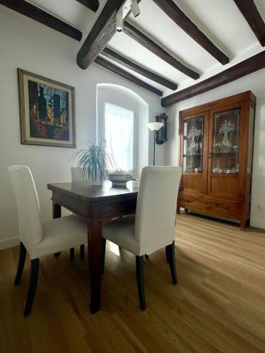 a dining room with a wooden table and white chairs at Casa Pierina in Vicchio