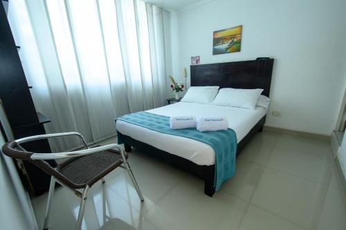 a bedroom with a bed and a chair in it at Hotel Villeta Suite in Villeta