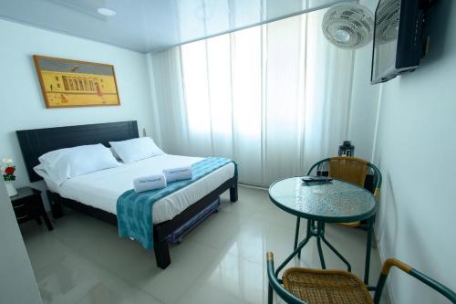 a bedroom with a bed and a table and a window at Hotel Villeta Suite in Villeta