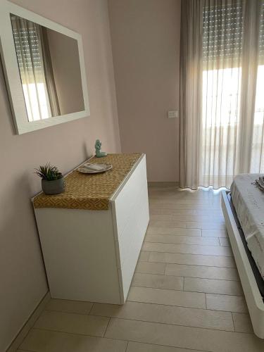 a bedroom with a dresser with a mirror and a bed at Appartamento Azzurro in Roseto degli Abruzzi