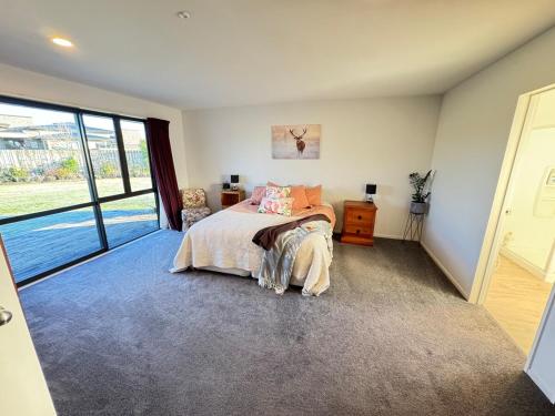 a bedroom with a bed and a large window at Private oasis and kid friendly space in Methven