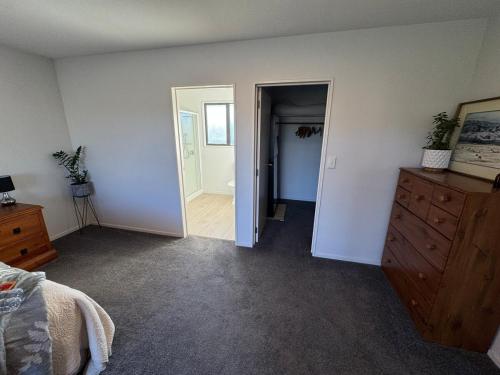 a bedroom with a dresser and a door to a hallway at Private oasis and kid friendly space in Methven