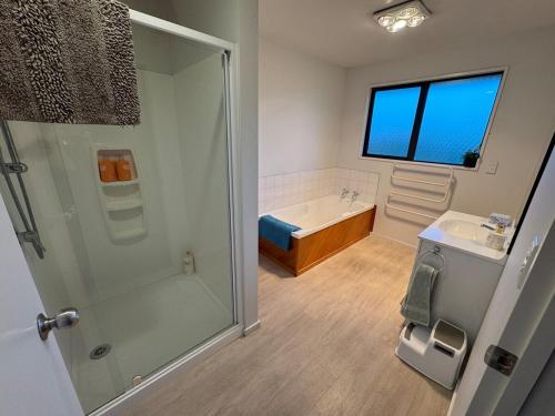 a bathroom with a shower and a sink and a tub at Private oasis and kid friendly space in Methven
