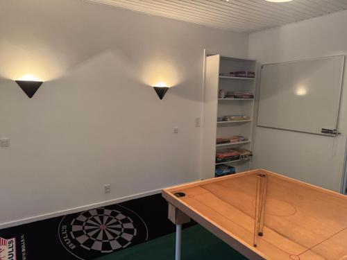 a ping pong table in a room with a dartboard at Hine Bakke Bed And Breakfast in Rudkøbing