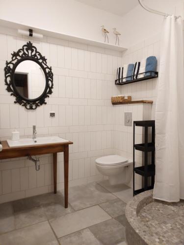 a bathroom with a sink and a toilet and a mirror at Tatowo in Darżlubie