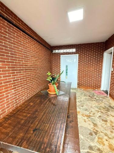 a empty room with a bench and a brick wall at Casa frente ao mar/pé na areia no Indaiá até 18 pessoas in Bertioga