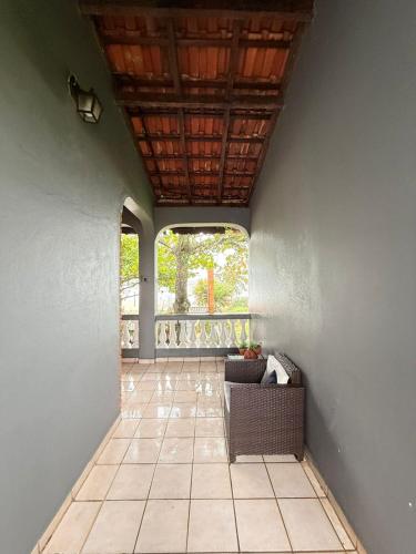 a hallway with a table and a couch in a room at Casa frente ao mar/pé na areia no Indaiá até 18 pessoas in Bertioga