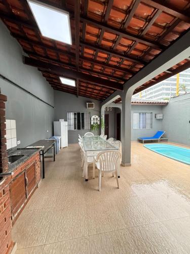 a patio with a table and chairs and a pool at Casa frente ao mar/pé na areia no Indaiá até 18 pessoas in Bertioga