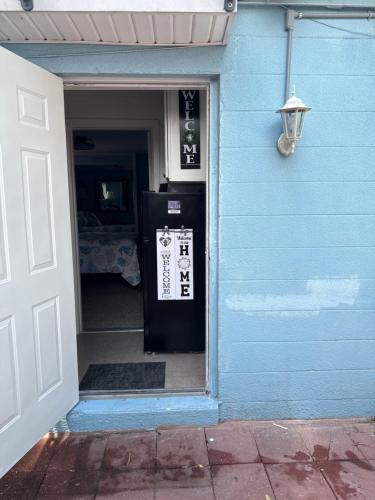 a door to a blue house with a sign on it at Studio Yunet in Bradenton