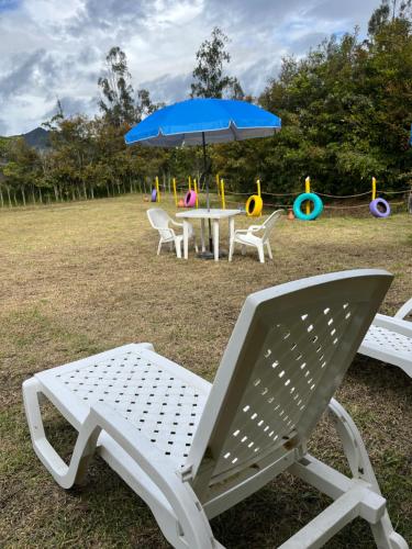 a picnic table and chairs with an umbrella and a playground at Ana Cereza Chalet in Nuevo Colón