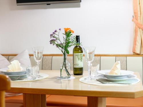a table with a bottle of wine and glasses at Schleicherhof III in Strass im Zillertal