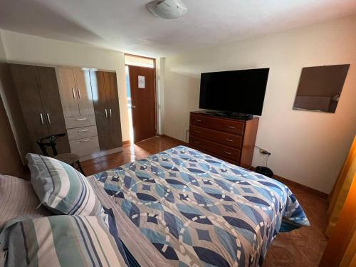 ein Schlafzimmer mit einem Bett und einem Flachbildfernseher in der Unterkunft Departamento entero dos habitaciones completamente amoblado in Arequipa