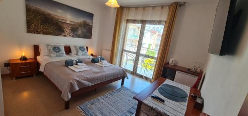 a bedroom with a bed and a large window at Villa Kapitańska in Kołobrzeg