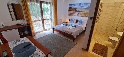 a small bedroom with a bed and a bathroom at Villa Kapitańska in Kołobrzeg
