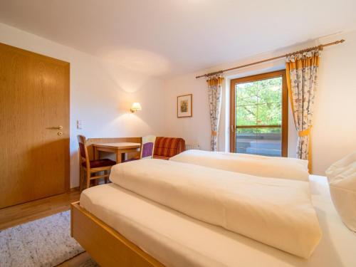 a bedroom with two beds and a desk and a window at Schleicherhof V in Strass im Zillertal