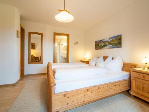 a bedroom with a large wooden bed with white sheets at Schleicherhof I in Strass im Zillertal