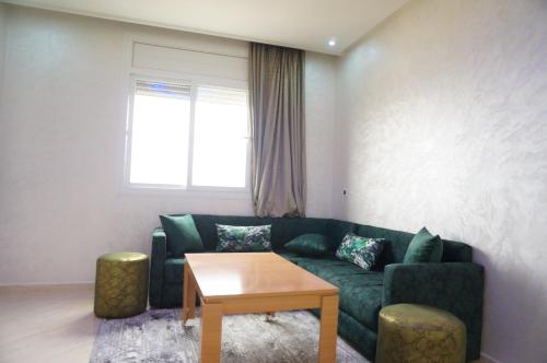 a living room with a green couch and a table at 2 Voies Résidence in Dakhla