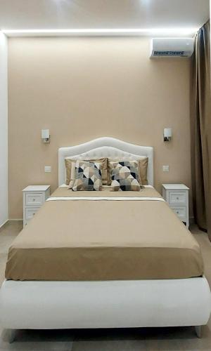 a bedroom with a large white bed with two night stands at Villa Anna al Duomo in Taormina