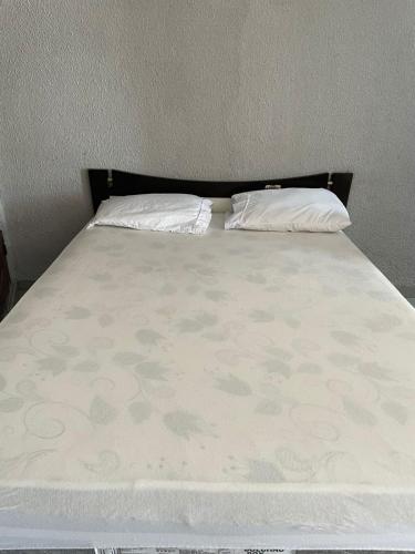 a bed with two pillows on top of it at Suíte Central in Palmas