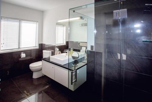 a bathroom with a sink and a toilet and a shower at Luxury on Rutherford in Hanmer Springs