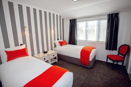 a hotel room with two beds and a window at Luxury on Rutherford in Hanmer Springs