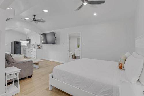 a white bedroom with a bed and a living room at The Palms Hotel in Key West