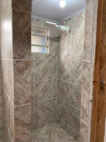 a shower with a glass door in a bathroom at Pouso dos Sinos in Ouro Preto