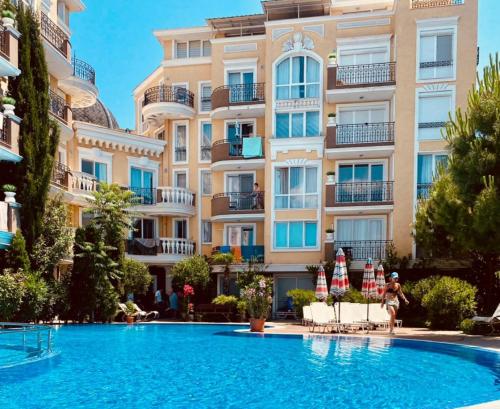 a hotel with a swimming pool in front of a building at Messembria Palace Bulgaria in Sunny Beach