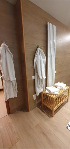 une pièce avec un banc, des manteaux et un radiateur dans l'établissement Les bonbonnettes, à Le Cailar