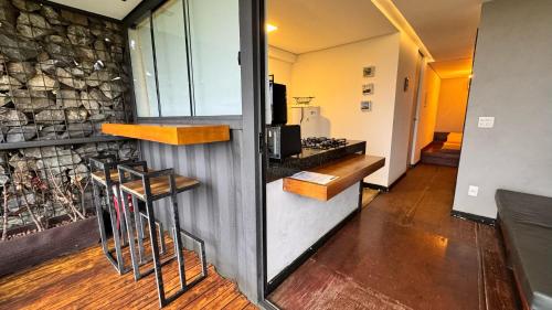 a kitchen with a counter and a stone wall at Docas da Lapa in Santana do Riacho