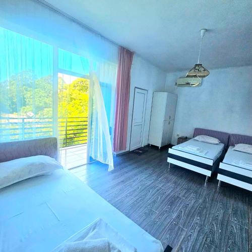 a bedroom with two beds and a large window at Villa "Rezi-dencia" in Batumi