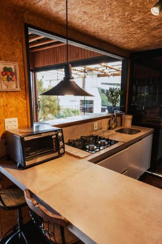 a kitchen with a counter top with a microwave at Docas da Lapa in Santana do Riacho
