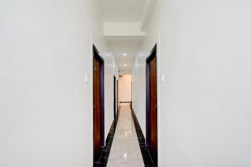 a hallway with white walls and wooden doors at Super Townhouse Oak Nagole Metro Station Formerly Saka Arcade in Upal