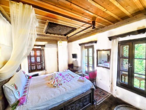 a bedroom with a large bed in a room with windows at ŞİRİNCEM PLUs in Izmir