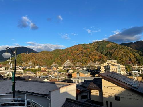 a view of a town with a mountain in the background at Guest House KANOKO in Nakatsugawa