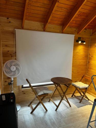 a large white screen in a room with a table and chairs at Cabañas en Valdivia in Valdivia