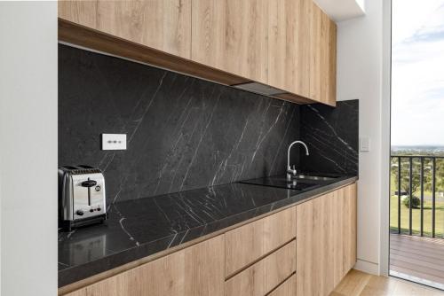 uma cozinha com um balcão preto e um lavatório em Mount View Estate One Bedroom Country Stay The Wisteria Escape em Mount View