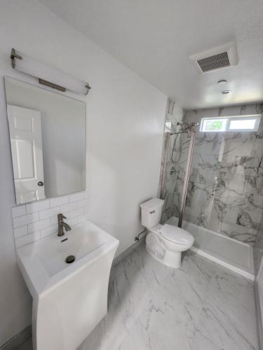 a white bathroom with a sink and a toilet at San Marino guest house in Los Angeles