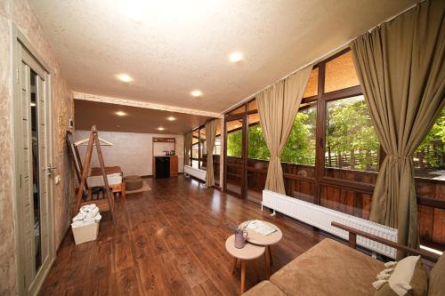 ステパナヴァンにあるEcoLife Lodge Hotel & Restaurantのウッドフロアのリビングルーム(大きな窓付)