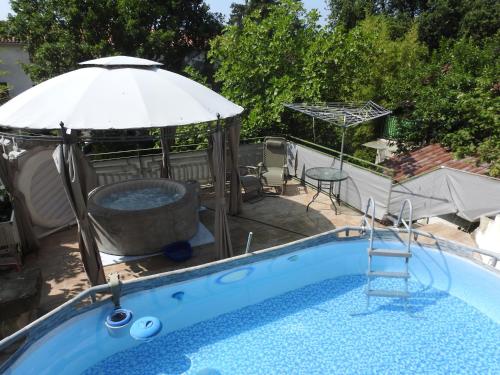 a swimming pool with an umbrella and a hot tub at Apartments with swimming pool Juradi, Central Istria - Sredisnja Istra - 21453 in Buzet