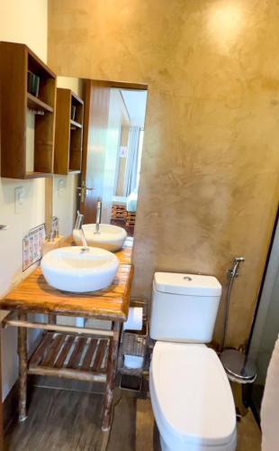 a bathroom with two sinks and a toilet at Docas da Lapa in Santana do Riacho