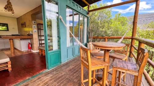 a porch with a hammock and a table and chairs at Docas da Lapa in Santana do Riacho