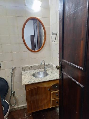un baño con lavabo y espejo en Suites dos Anjos, en Arraial do Cabo