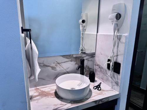 a bathroom with a sink and a hair dryer at Casa ZeRo in Manzanillo
