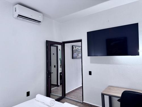 a room with a mirror and a tv on the wall at Casa ZeRo in Manzanillo