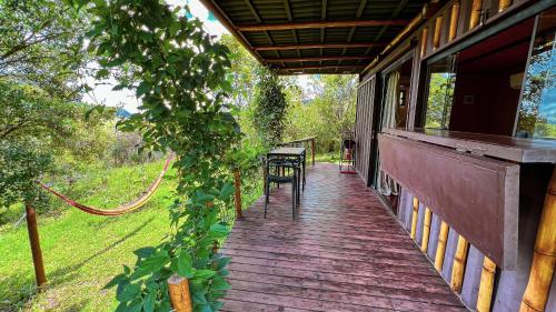 a porch of a house with a table and chairs at Docas da Lapa in Santana do Riacho