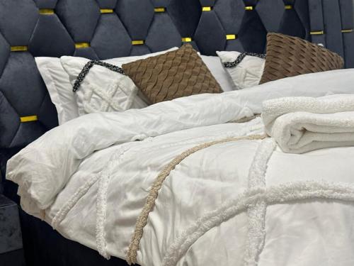 a bed with white sheets and pillows on it at plsa 2bedroom at airport city in Accra