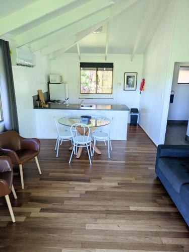 a living room with a table and chairs at Alstonville Country Cottages in Alstonville