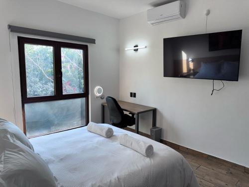 a bedroom with a bed with a desk and a window at Casa ZeRo in Manzanillo